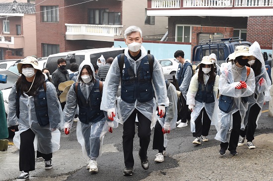 장영수 총장(맨 앞)과 부경대생들이 보슬비가 내린 22일 오전 부산 문현동 주택가에서 지게를 지고 연탄을 나르고 있다.(사진제공=부경대)