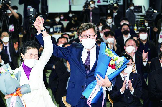 국민의힘 박형준 부산시장 후보가 7일 오후 부산진구 선거사무소에서 꽃다발을 들고 부인 조현 여사와 함께 기뻐하고 있다.(사진제공=박형준 후보)