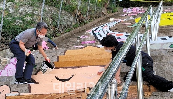 이야기가 있는 '계단벽화'를 그리고 있다. [제공=북구청]