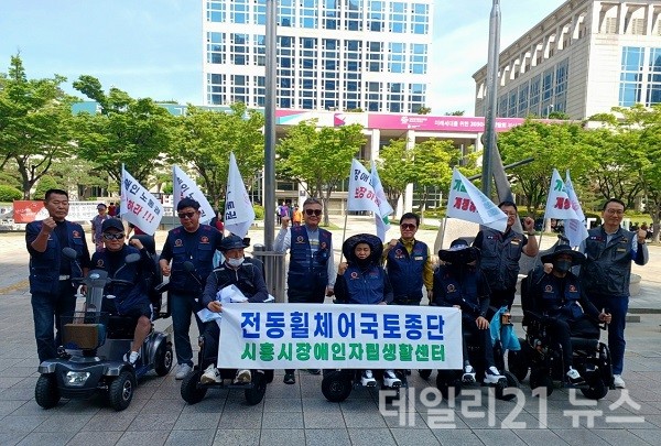 7일 한국장애인노동조합총연맹 기초생활수급장애인들이 기초생활보장법 개정을 촉구하는 전동휠체어 국토종단 행진에 앞서 촬영을 하고 있다.(사진=데일리21)